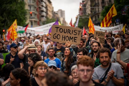 Manifestantes corean lemas contra el Formula 1 Barcelona Fan Festival en el centro de Barcelona, España, el miércoles, el 19 de junio de 2024, con protestas contra el turismo masivo.