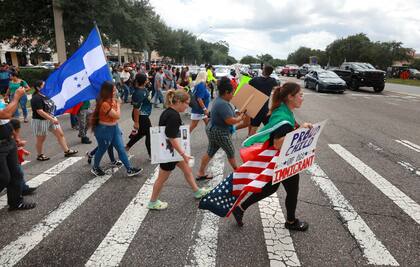 Manifestantes cruzan una calle, el jueves 1° de junio de 2023, en Orlando, Florida, durante una protesta contra la nueva ley de inmigración de Florida que promulgó el gobernador Ron DeSantis (Joe Burbank/Orlando Sentinel via AP)