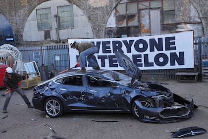 Manifestantes golpean un vehículo Tesla que iba a ser desechado, durante un evento organizado por el grupo "Todo mundo odia a Elon" el 10 de abril de 2025 en Londres. (AP Foto/Kirsty Wigglesworth)