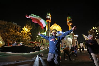 Manifestantes iraníes ondean una bandera palestina mientras se reúnen en la Plaza Palestina de Teherán el 14 de abril de 2024, después de que Irán lanzara un ataque con aviones no tripulados y misiles contra Israel