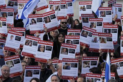 Manifestantes israelíes muestran pancartas con los rostros y nombres de personas que se cree que fueron tomadas como rehenes y retenidas en Gaza, durante una protesta en Trafalgar Square, Londres (AP Photo/Frank Augstein)