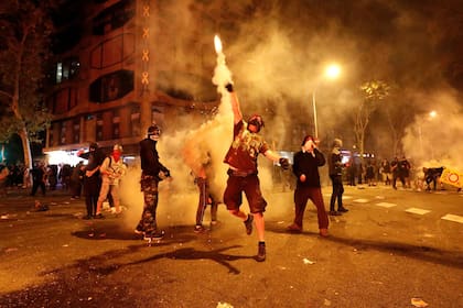 Manifestantes lanzan una granada de gas lacrimógeno a la policía, en las protestas de Barcelona