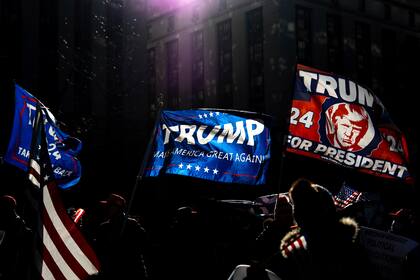 Manifestantes ondean banderas del presidente electo Donald Trump afuera de una corte en Manhattan luego de su sentencia en el caso de pagos a una actriz porno para mantener su silencio, el viernes 10 de enero de 2025, en Nueva York. (AP Foto/Julia Demaree Nikhinson)