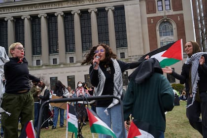 Manifestantes pro palestinos cantan y bailan en el Campamento en Solidaridad de Gaza en el campus de la Universidad de Columbia en Nueva York el domingo 21 de abril de 2024.