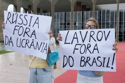 Manifestantes protestan frente al Palacio Itamaraty sosteniendo carteles que dicen en portugués "Rusia, fuera de Ucrania" y "Lavrov, fuera de Brasil" durante la visita del ministro de Relaciones Exteriores de Rusia, Sergei Lavrov, en Brasilia, Brasil, el lunes 17 de abril de 2023. 