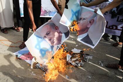 Manifestantes queman fotos del Primer Ministro israelí Benjamin Netanyahu en Deir Al-Balah, Territorios Palestinos