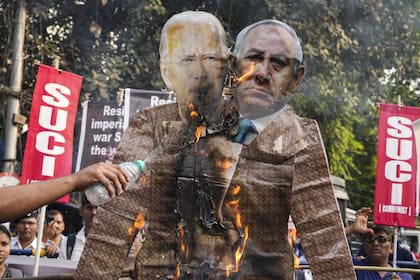 Manifestantes queman un cartel del presidente estadounidense Joe Biden y del primer ministro israelí Benjamin Netanyahu durante una concentración en Calcuta, India, 1 de noviembre de 2023.