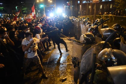 Manifestantes se enfrentan a la policía en Lima, en una protesta en contra de la destitución de Vizcarra