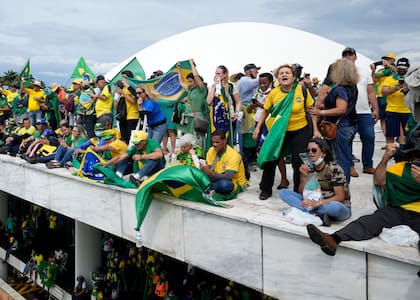 Manifestantes, simpatizantes del expresidente brasileño Jair Bolsonaro, en el techo del edificio del Congreso Nacional después de irrumpir en el recinto, el domingo 8 de enero de 2023, en Brasilia. 