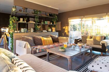 Detrás de la estantería (Poligraph) que llega hasta el techo, organizaron el living con amplios sillones (Diamante Sillones), una lámpara ‘Cinema’ (Sentido) y muchísimos almohadones.