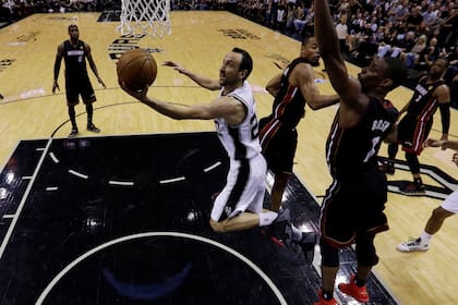 Manu Ginobili dispara el balón contra el centro de Miami Heat Chris Bosh en el quinto juego de las Finales de la NBA 2014 en el AT & T Center