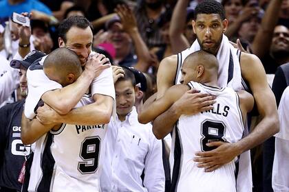 Manu Ginobili, Tony Parker, Patty Mills y Tim Duncan de los San Antonio Spurs celebran en el banquillo en los minutos finales del Juego 5 de las Finales de la NBA 2014 contra Miami Heat en el AT&T Center en junio 15, 2014 en San Antonio