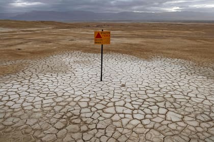 Una señal de advertencia de mina en un área marina seca que expuso y creó una llanura de sal, a unos 20 kilómetros al sur del Kibbutz Ein Gedi israelí