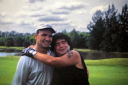 Maradona y Cóceres se abrazan durante el match de golf en el Pilar Golf Club