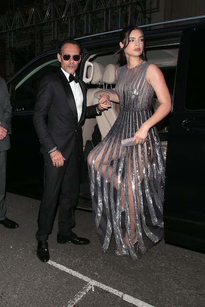 Marc Anthony y su mujer, Nadia Ferreira, llegan a la superfiesta. Ella impactó con un vestido metalizado con transparencias.