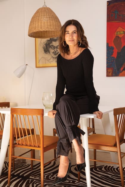 Marcela posa sentada sobre la mesa del comedor. Aún conserva la soltura y esponteneidad frente a la cámara de su época de modelo.
