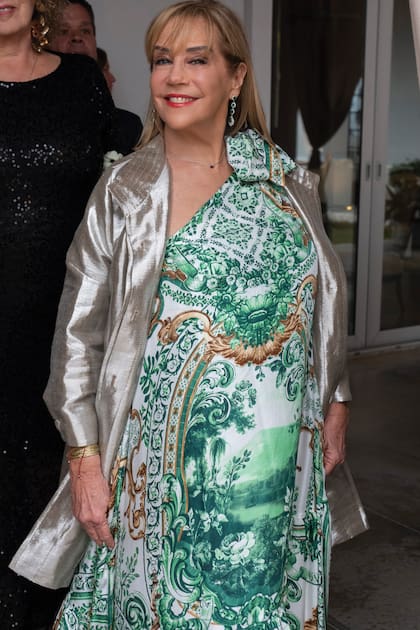 Marcela Tinayre, con vestido estampado y trench plateado