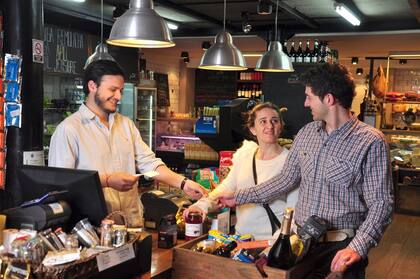 Marcelo Zucchelli paga las compras en The Pick Market; su mujer, Aldana Antonozzi, lleva los gastos del auto