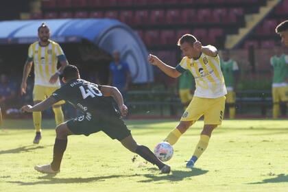 Marco Ruben, referente de Rosario Central, remata ante el intento de bloqueo de Rafael Delgado, defensor de Colón