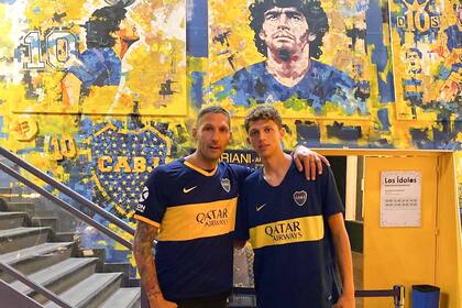 Marco y su hijo, Davide, que le pidió de regalo, por sus 18 años, conocer la Bombonera; en el museo xeneize, atrás, la imagen de Diego...