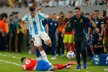 Marcos Acuña lucha por la pelota con Nicolás Fernández ante la mirada de Lionel Scaloni durante el partido que disputaron las selecciones de Chile y Argentina, por la Copa América 2024 en el MetLife Stadium, New Jersey, el 25 de junio de 2024.