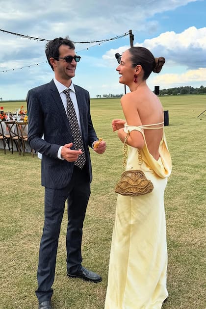 Marcos Miguens y Violeta Juni, íntimos de los novios. La arquitecta y modelo impactó con un vestido de satin con espalda de vértigo.