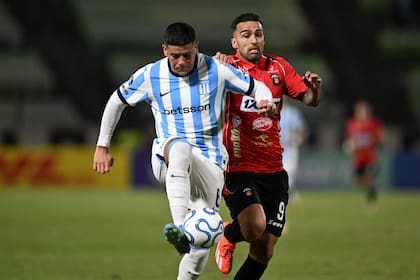 Marcos Rojo se lleva la pelota ante la presión de Adrián Fernández, de Caracas; Racing igualó en Venezuela por la Copa Sudamericana