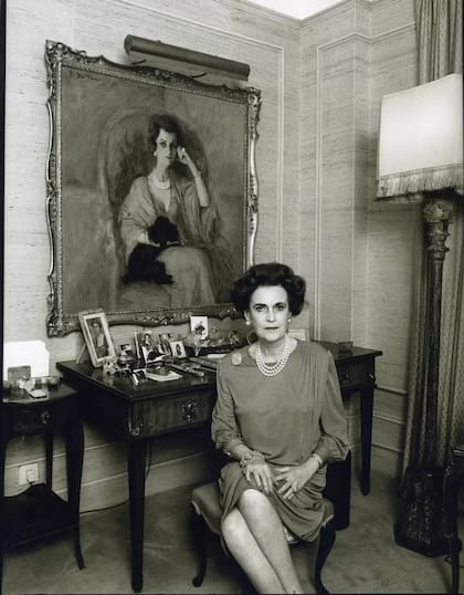 Margaret Campbell, duquesa de Argyll en un apartamento en el hotel Grosvenor House, Londres, alrededor de 1990, sentada frente a un retrato suyo pintado en 1960 por René Bouche.