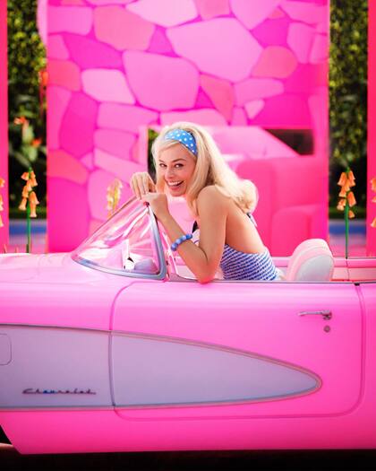 Margot Robbie a bordo del típico vehículo rosa de Barbie