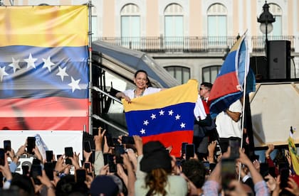 María Corina Machado con una bandera venezolana, junto a sus seguidores en Puerta del Sol, Madrid.