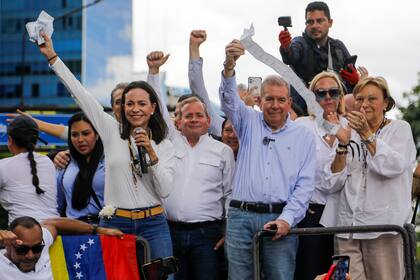 María Corina Machado y el candidato opositor en las presidenciales, Edmundo González Urrutia, muestran documentos de conteo de votos desde lo alto de un camión durante una protesta contra los resultados de las elecciones que dieron a Nicolás Maduro como vencedor, en Caracas, Venezuela, el 30 de julio de 2024. (AP Foto/Cristian Hernandez)