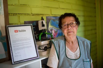 María Elena Arévalo posa junto a un reconocimiento de Youtube durante la entrevista con la AFP en su casa de Llay-Llay, al noroeste de Santiago de Chile, el 19 de diciembre de 2023