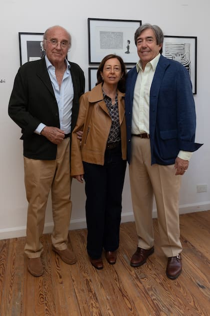 María Elena "Mimi" Blaquier Arrieta junto a su hermano, Jandri (actual presidente de Ledesma). A la izquierda, Pedro Silvestri, marido de Mimi. Los tres posan delante de un grupo de fotografías de Jandri, realizadas en blanco y negro