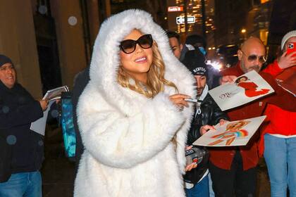 Mariah Carey firma autógrafos para sus fans mientras se dirige al Madison Square Garden para su concierto de Navidad