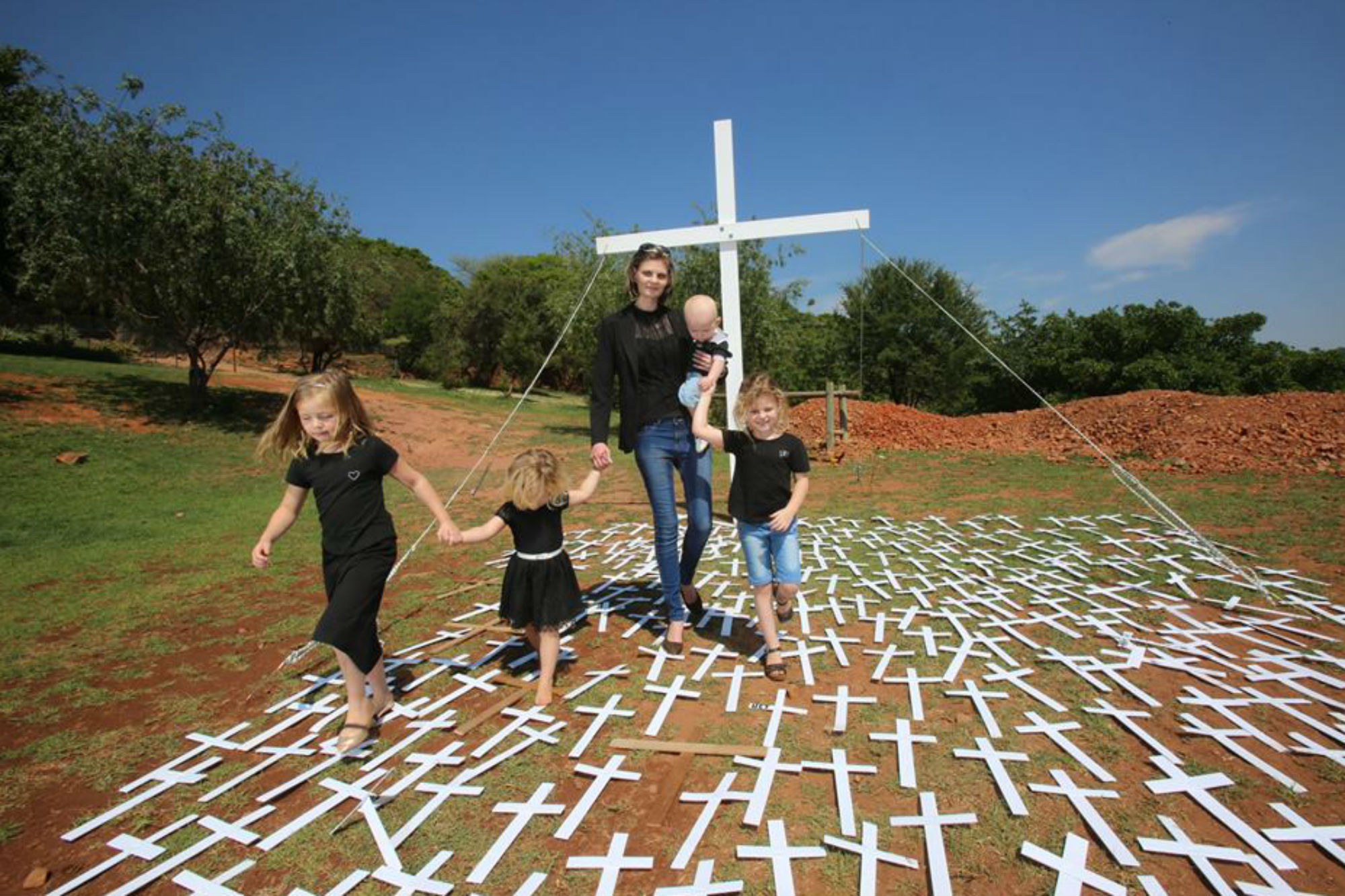Mariandra Heunis con sus hijos en el cementerio durante un encuentro de solidaridad contra los asesinatos en las granjas. Su vuda cambió desde el asesinato de Johan. Ahora mantiene sola a su familia trabajando como organizadora de entierros.