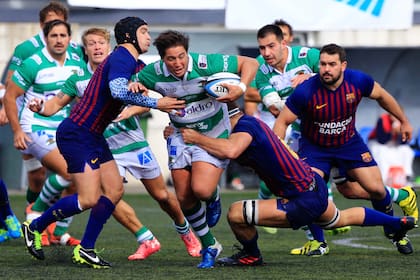 Mariano García, de Independiente, tackleado por dos hombres de Barcelona.