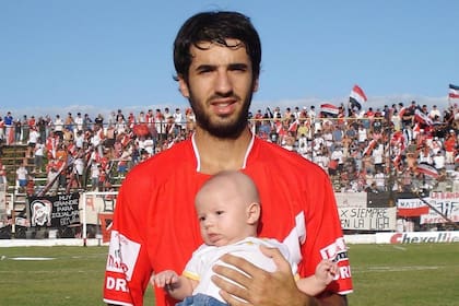 Mariano Echeverría, con la camiseta de Deportivo Maipú. En sus brazos, sostiene a su hijo Galo