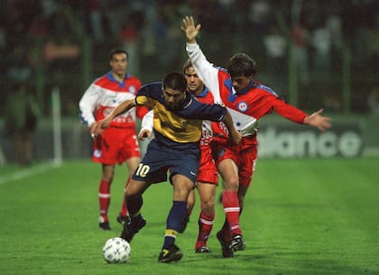 Mariano Herrón, volante central de Argentinos, persiguiendo a Juan Román Riquelme, enganche de Boca, en la cancha de Ferro, por el Apertura 99