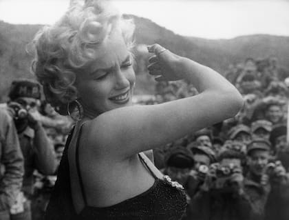 Marilyn Monroe se protege los ojos de los flashes mientras entretiene a las tropas estadounidenses en Corea del Sur