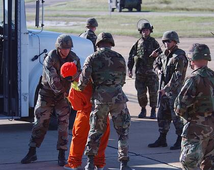 Marines trabajando en parejas custodiando a los primeros 20 prisioneros que fueron llevados desde Afganistán a la Base Naval de Guantánamo en Cuba el 11 de enero de 2002.