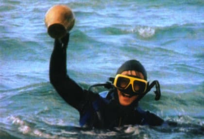 Mario Brozoski, uno de los cuatro intrépidos adolescentes que encontraron el buque, rescata del fondo del mar un jarrón -intacto- del siglo XVIII