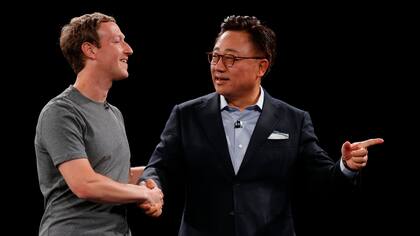 Mark Zuckerberg le da la mano, en el escenario, a DJ Koh, jefe del negocio de smartphones de Samsung