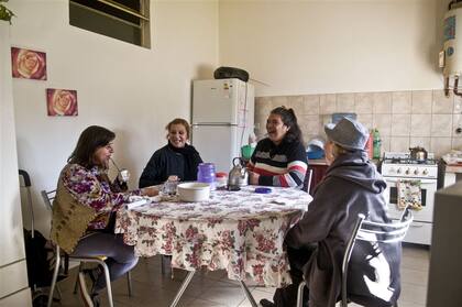 Marta, Helen, Gaby y Mariana toman mate y charlan en la cocina de su casa