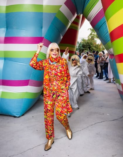 Marta Minujín con sus dobles y una de sus esculturas instaladas en el Miami Design District
