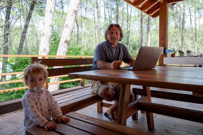 Martín Bonilla con el menor de sus cinco hijos. La familia se instaló a fines de 2019 para pasar el verano, sin pensar que terminarían radicándose de manera definitiva