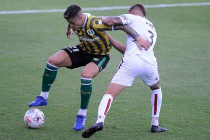 Martín Payero la pisa ante la marca de Gonzalo Piovi, en un Banfield-Colón