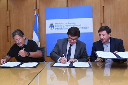 Martínez, Moroni y Arroyo, ayer, al firmar un convenio con la Uocra