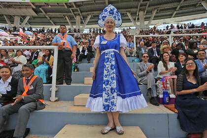 Michas mujeres con vestidos y polleras largas y holgadas y el atalaya bajo el brazo, y los hombres de corbata o moño