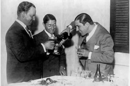 El preparador de caballos Francisco Maschio, Irineo Leguisamo y Carlos Gardel, en Montevideo, durante una celebración de cumpleaños del cantor
