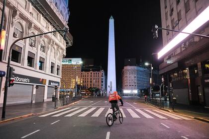 Un repartidor de comida transita a contramano por la Avenida Corrientes y 9 de Julio, en la zona céntrica de Buenos Aires inusualmente vacía, debido a las restricciones de circulación por la pandemia